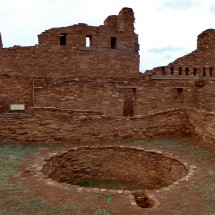 Mission of San Gregorio de Abó with a round Kiva of the Indian people in the foreground